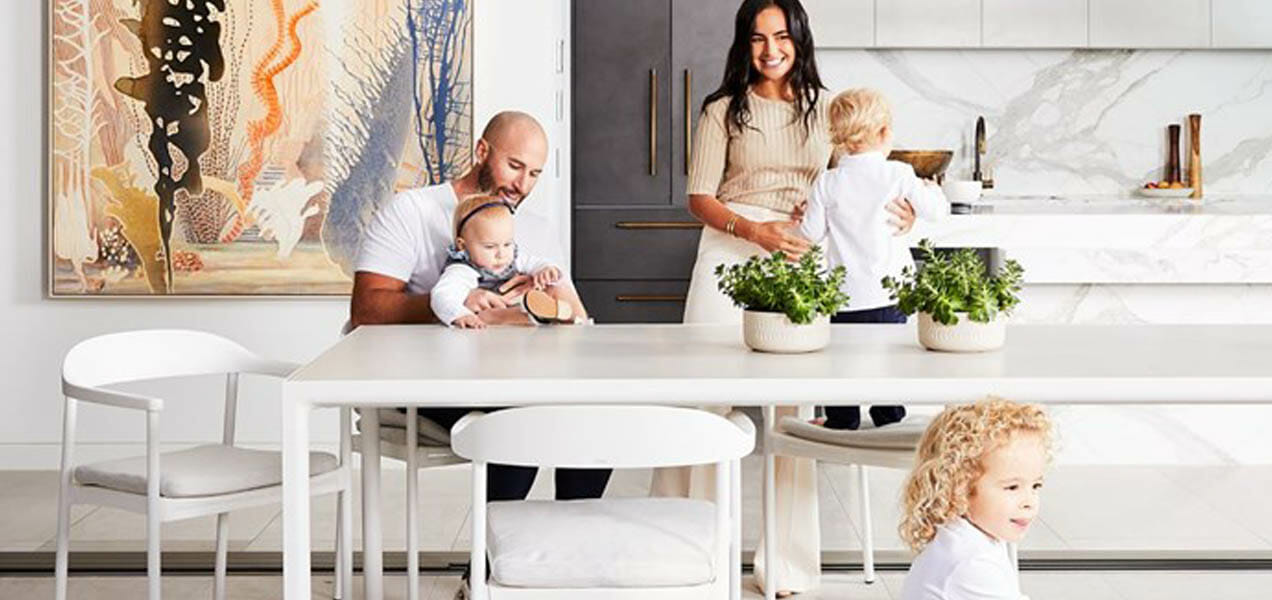 Business owner at home with children, small dog and husband in beautiful white and airy modern kitchen