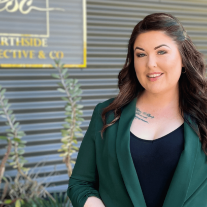 Brunette women with a green blazer smiling infront of beauty salon