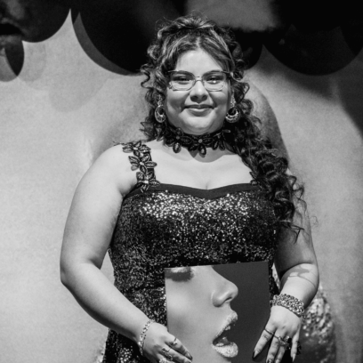 Student with certificate in front of balloons on stage