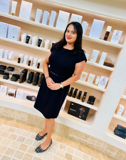 women smiling in front of skincare products on shelf