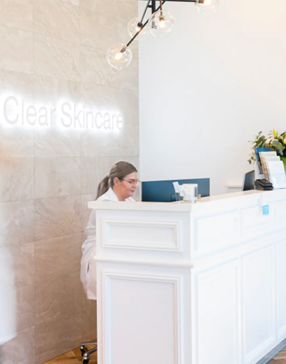 skincare clinic reception with a women sitting at white desk