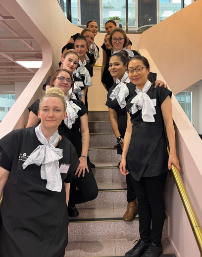 Students smiling for a photo on a staircase