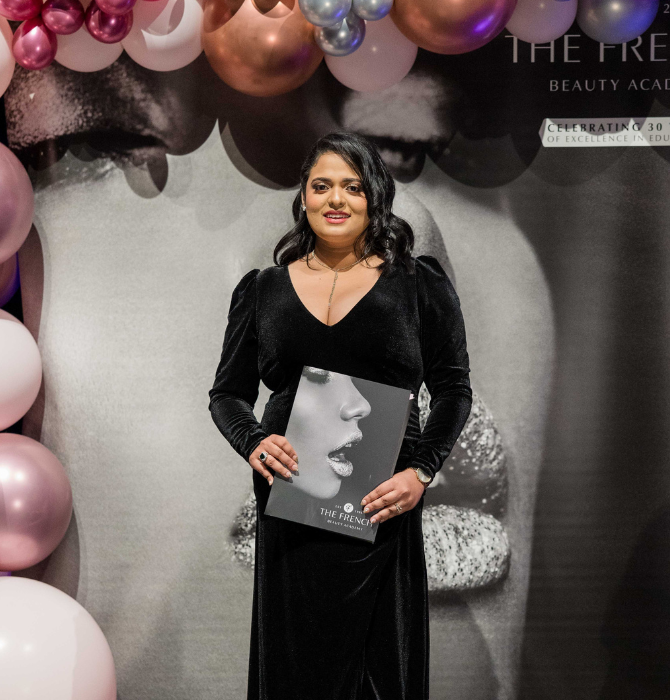 Graduating student wearing a formal gown smiling for a photo with certificate