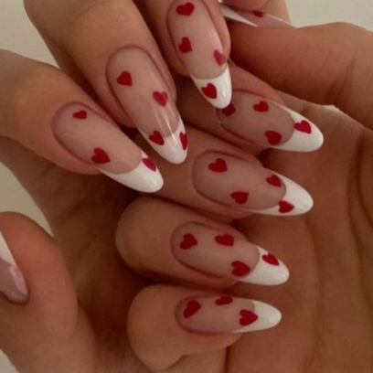 An elegant French manicure with red heart nail art for Valentines day