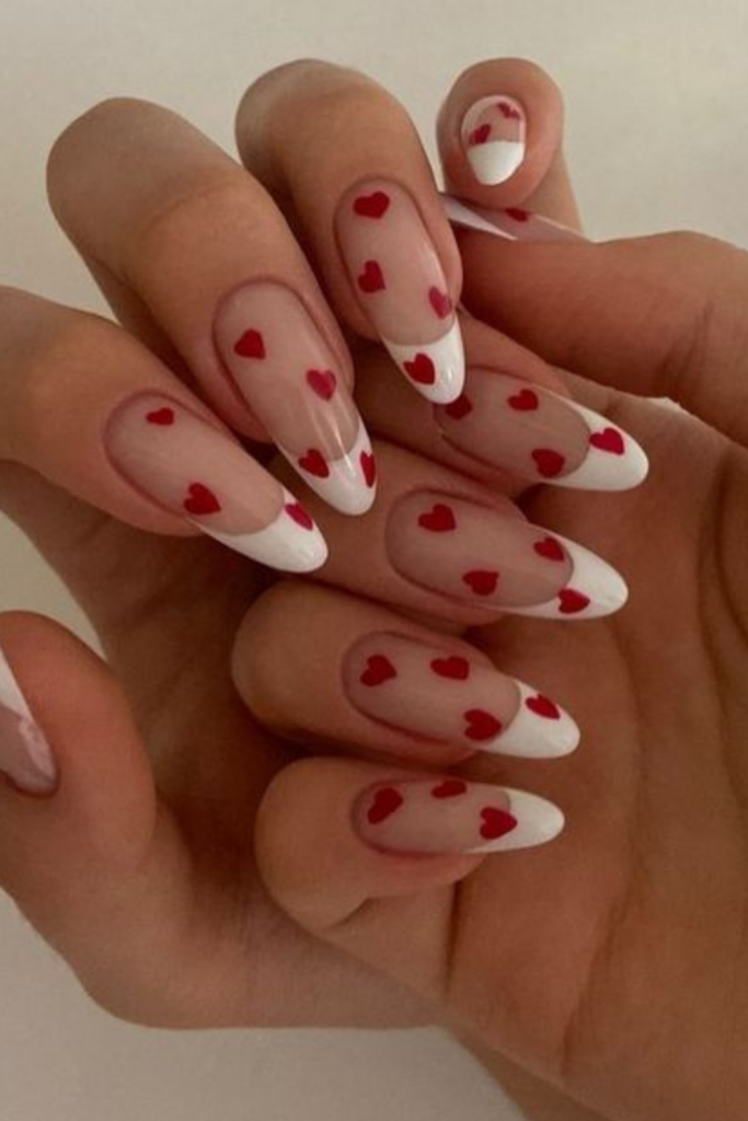 An elegant French manicure with red heart nail art for Valentines day